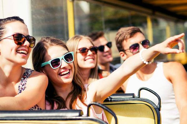 Jóvenes sonriendo durante un recorrido turístico en autobús