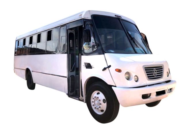 Minibús blanco tipo shuttle con puerta lateral abierta